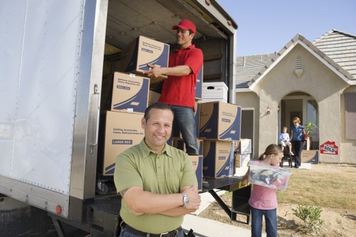 Household items being loaded in a suburban street with limited parking