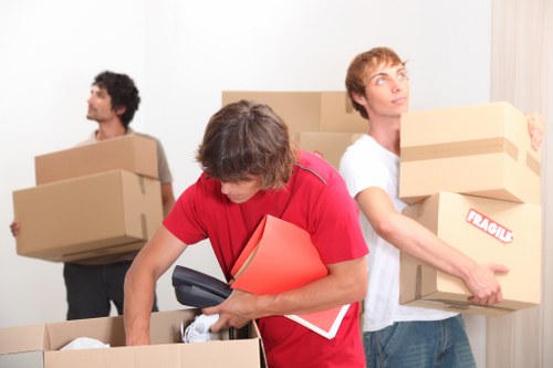 Professional movers carrying furniture through a Dulwich property with care