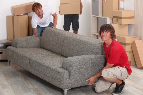 Professional movers carrying household items from a Dulwich property